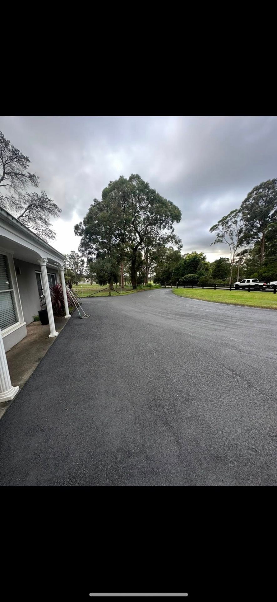 Freshly laid asphalt driveway around homestead