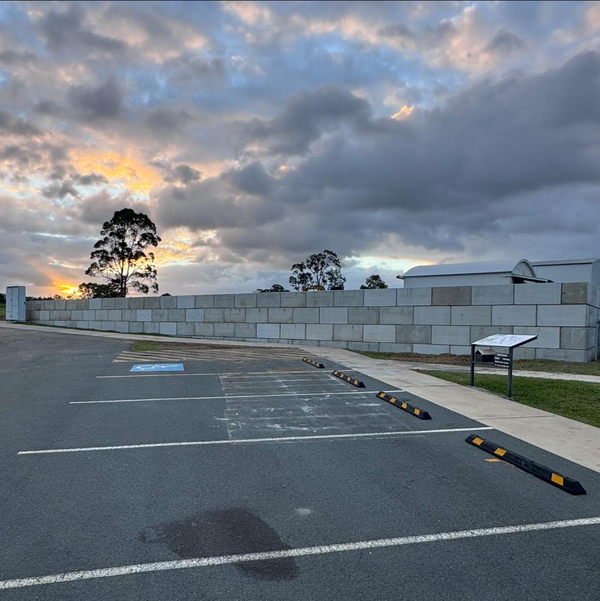 Concrete block wall & sealed carpark at sunset