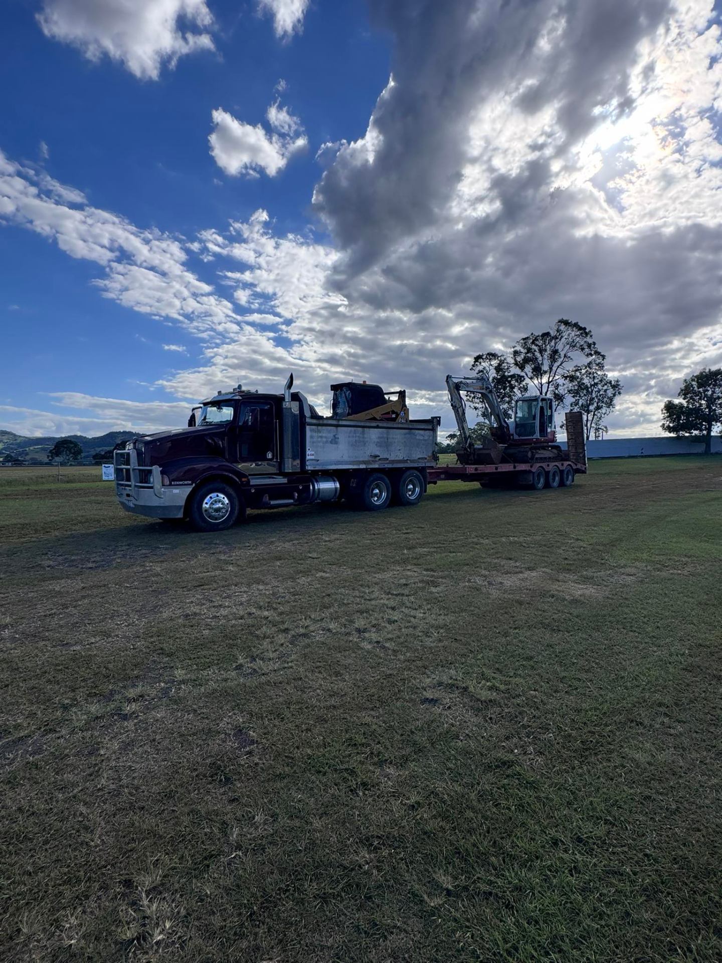 Kenworth with loaded float in open paddock