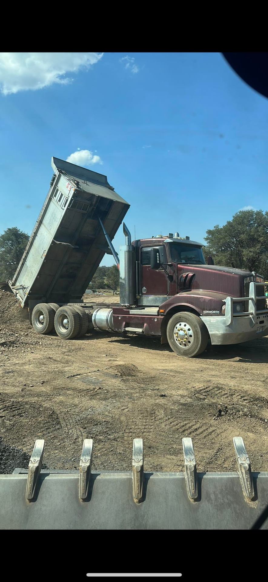 Kenworth tipper unloading material on site