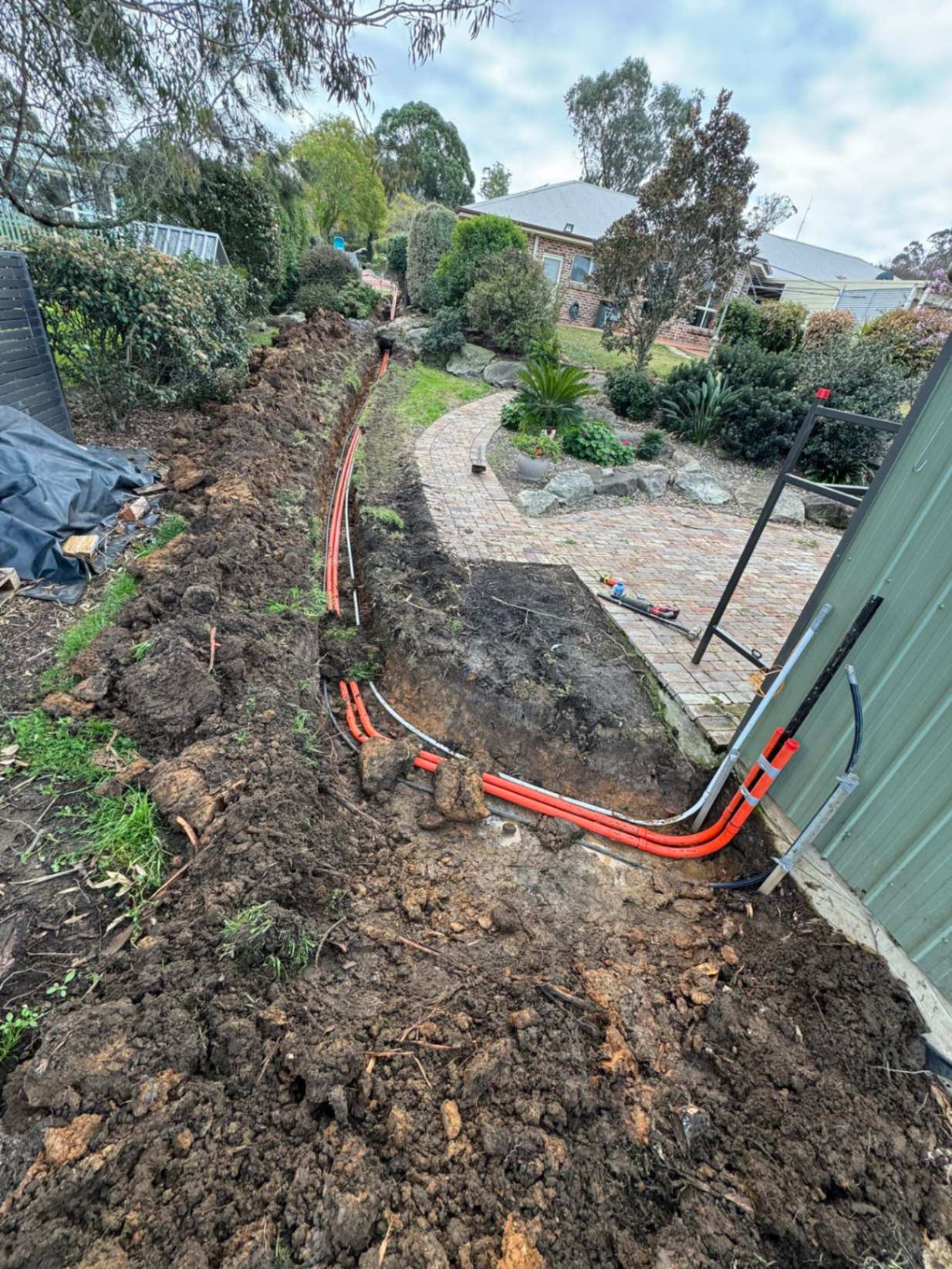 Service trench & conduit run alongside shed