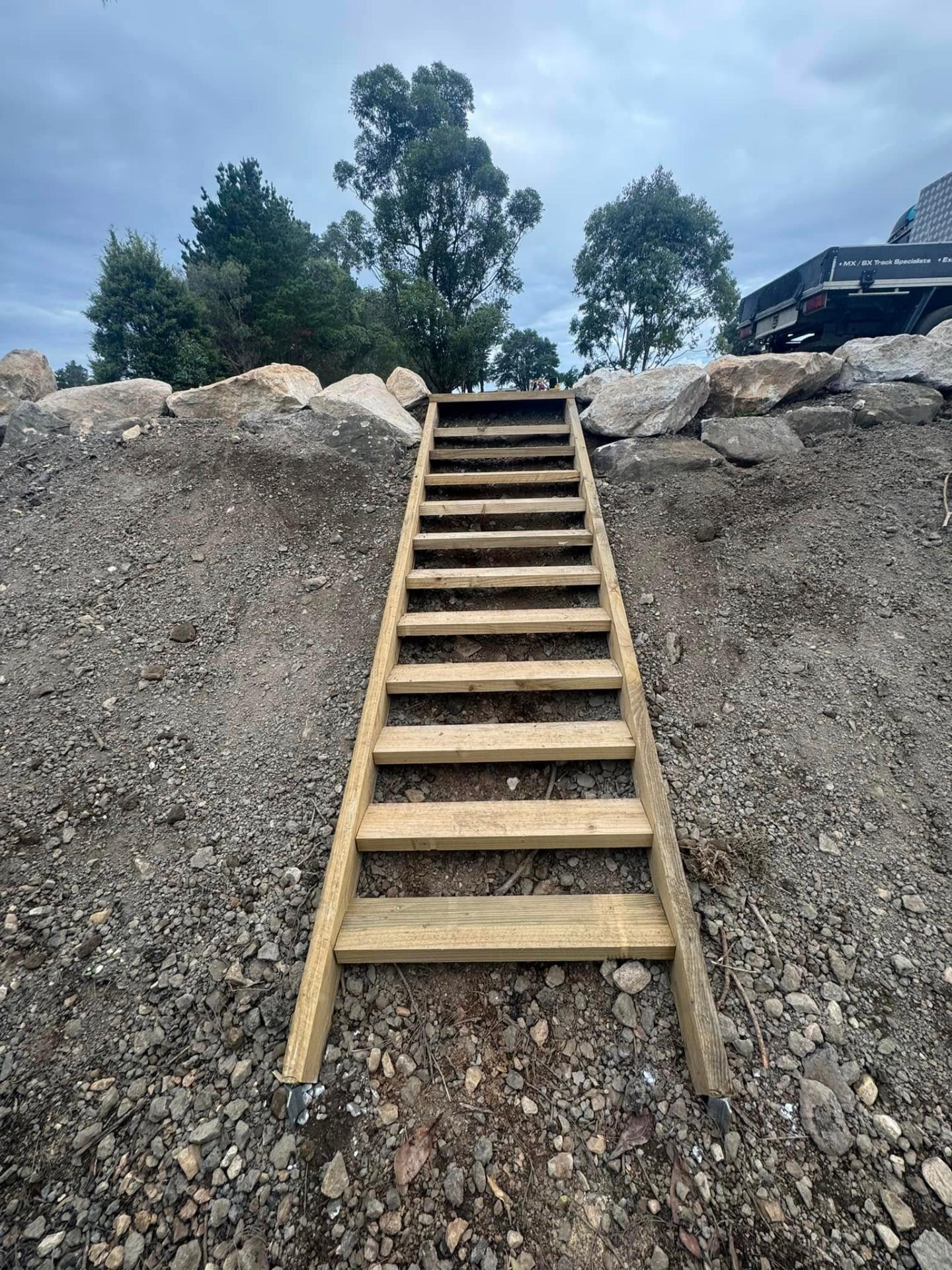 Hardwood access stairs on rock retaining wall